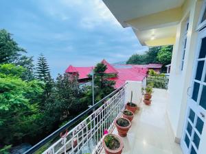 a balcony with potted plants on a building at Grand view lodge and Restaurant Dharamshala - Partial Prepayment required to confirm booking in Dharamshala