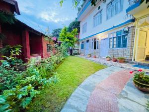 a walkway between two buildings in a yard at Grand view lodge and Restaurant Dharamshala - Partial Prepayment required to confirm booking in Dharamshala