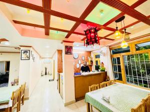 un comedor con 2 mesas y un bar en Grand view lodge and Restaurant Dharamshala, en Dharamshala