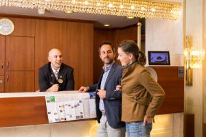 a group of three people standing at a counter at City Appartements - Hotel City Central in Vienna