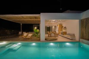 奧林匹亞達的住宿－Aristotelia Gi - Premium Luxury Villas with Private Pools，夜间在房子前面的游泳池