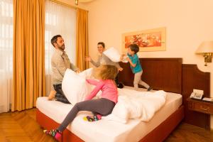 una familia jugando en una cama en una habitación de hotel en City Appartements - Hotel City Central, en Viena