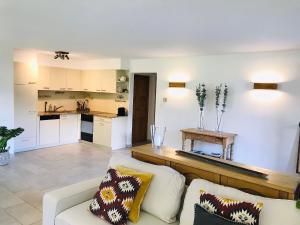 a living room with a couch and a kitchen at Chalet la Tulipe, mountain view, Terrace, BBQ in Nendaz