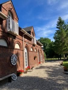 un edificio de ladrillo con un banco delante de él en La Marokanette, en Saint-Maclou-de-Folleville