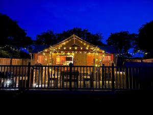 Una casa con luces de Navidad encendidas por la noche en Jungle Book Safari Tent en Tenby