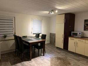 a room with a table and chairs and a kitchen at Wohnung am Wasserturm in Ilsede