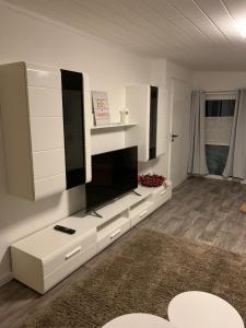 Una sala de estar con un televisor de pantalla plana en una pared. en Wohnung am Wasserturm, en Ilsede 4 fotos más