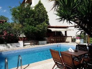 a pool with a table and chairs next to a house at Epic Studios Kallithea in Kallithea Halkidikis