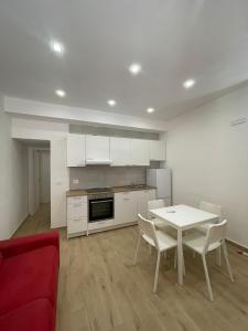 a kitchen with a white table and a red couch at GM IMMOBILIARE in Reggio di Calabria