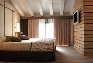 a bedroom with a bed and a large window at Hotel Filanda in Cittadella