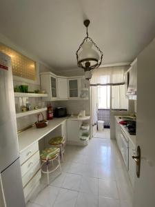 una cocina con armarios blancos y una lámpara de araña en luxury's villas, en Villacarrillo