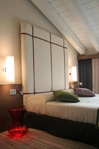 a bedroom with a large bed with two lamps at Hotel Filanda in Cittadella