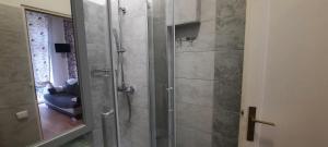 a shower with a glass door in a bathroom at Lorf Hostel&Apartments in Krakow