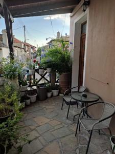 a patio with tables and chairs and potted plants at Plumbago Apartment in Theologos