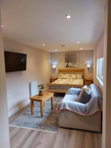 um quarto com uma cama, um sofá e uma televisão em Southwell Home Stay em Southwell