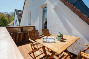 a wooden table and chairs on a balcony at Stewohood Norderney in Norderney