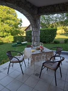 einen Tisch und Stühle auf einer Terrasse in der Unterkunft Kuća za odmor VB-IDRO in Tuhelj