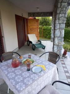 einen Tisch mit einem Teller Essen auf einer Terrasse in der Unterkunft Kuća za odmor VB-IDRO in Tuhelj