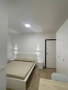 a white bedroom with a bed and a mirror at GM IMMOBILIARE in Reggio di Calabria