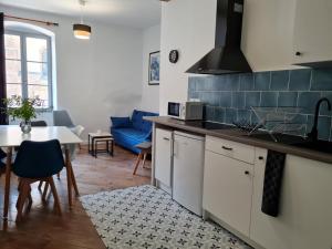 uma cozinha e sala de estar com mesa e cadeiras em Triplex avec vue sur place du centre historique. em Foix