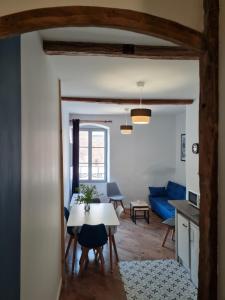 uma sala de estar com uma mesa e um sofá azul em Triplex avec vue sur place du centre historique. em Foix
