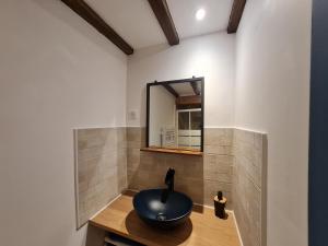 um banheiro com uma pia e um espelho em Triplex avec vue sur place du centre historique. em Foix