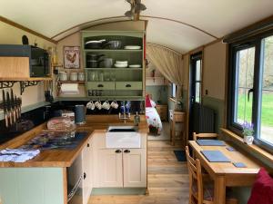 a kitchen and dining area of a tiny house at Brook the Shepherd Hut in Saltash