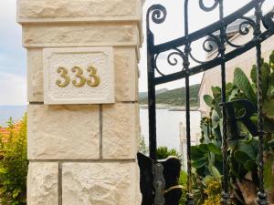 a sign on a stone pillar next to a gate at Apartments Ranko in Zavalatica