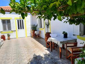a patio with a table and chairs in a house at Lemon Garden 2 in Karídhion