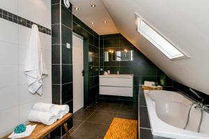 een badkamer met een wastafel en een ligbad bij Brinkzate - De Brink in Dwingeloo +13 foto's