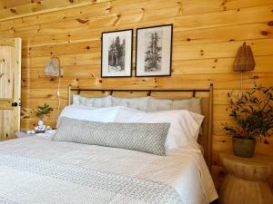 una camera con un letto bianco su una parete in legno di Sweet Tea Timber Indoor Pool Hot Tub a Pigeon Forge