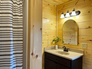 un bagno con lavandino e specchio di Sweet Tea Timber Indoor Pool Hot Tub a Pigeon Forge Altre 42 foto