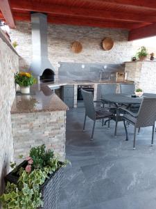 Apartma Sebastjan Dobova near Terme Paradiso في Dobova: مطبخ خارجي مع طاولة وكراسي