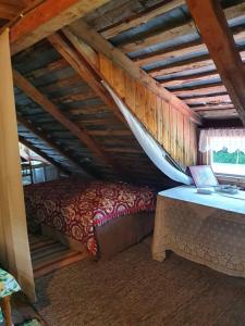 a bedroom with a bed and a table in a attic at Villa Puistola Vinttimajoitus in Hämeenlinna