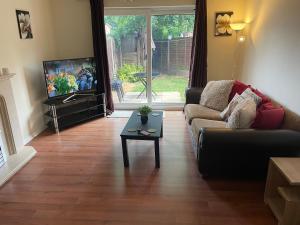 a living room with a couch and a tv and a table at The Swallows Popular Location 3 Bedroom House FREE WI-FI and SKY TV IN ALL ROOMS in Rough Close