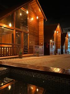 a house with a wooden deck at night at Mi Margarita Chalets in Alausí