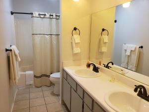 y baño con lavabo, aseo y espejo. en Multi Resorts at Eagles Nest en Branson