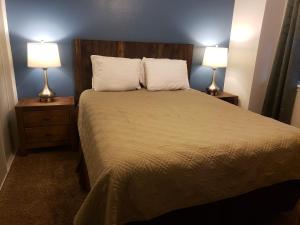 a bedroom with a large bed with two lamps at Multi Resorts at Eagles Nest in Branson