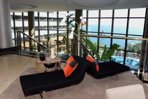 uma sala de estar com um sofá preto e uma mesa em Enotel Lido - All Inclusive em Funchal