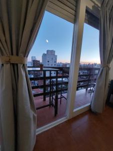 a room with a balcony with a view of the city at Tu Lugar en Mardel in Mar del Plata