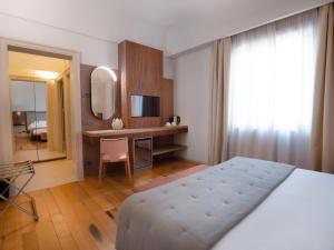 1 dormitorio con cama, escritorio y espejo en Villa Favorita Hotel & Events, en Marsala