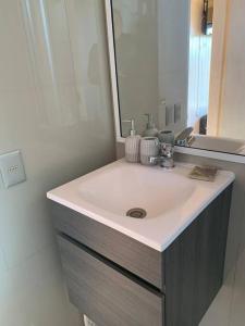 y baño con lavabo blanco y espejo. en Cabaña para dos personas en Punta de Lobos PUERTO LA MAR, en Pichilemu