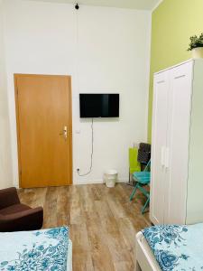 a room with a bed and a door with a television at Pension Kaffeefreunde in Berlin