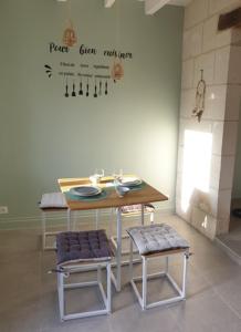 einen Tisch und zwei Hocker in einem Zimmer in der Unterkunft Logis de charme en Touraine in Sainte-Maure-de-Touraine