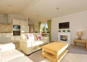 sala de estar con 2 sofás blancos y chimenea en Ribble Valley View en Langho