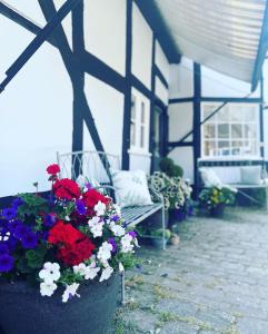 a porch with a bench and flowers on a patio at Humbug Cottage in Much Wenlock