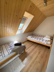 a attic bedroom with two beds and a wooden ceiling at Beskidzki Reset in Budzów