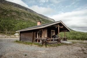 a small log cabin with a mountain in the background at Villa Pikku Saana in Kilpisjärvi