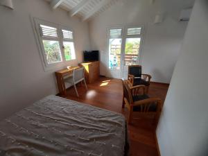 Schlafzimmer mit einem Bett, einem Tisch und Stühlen in der Unterkunft Bungalow Bleu in Baie-Mahault