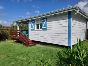ein kleines Haus mit einer Bank davor in der Unterkunft Bungalow Bleu in Baie-Mahault